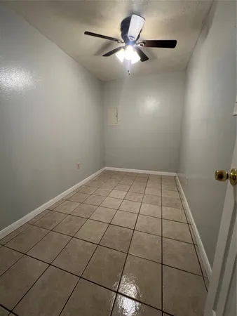 an empty room with a ceiling fan and a rug