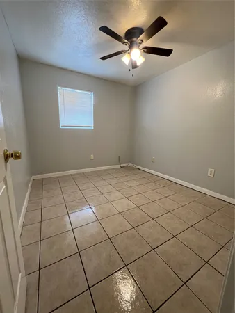 a view of an empty room with a chandelier fan