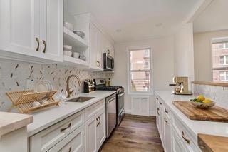 9201 Shore Road, Unit C209 Brooklyn, NY 11209 - Photo 6 of 23 a kitchen with stainless steel appliances granite countertop a sink stove cabinets and wooden floor
