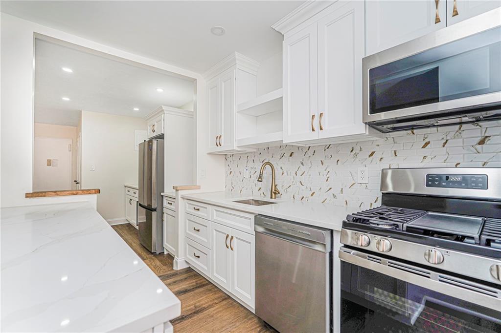 9201 Shore Road, Unit C209 Brooklyn, NY 11209 - Photo 7 of 23 a kitchen with stainless steel appliances a stove microwave and refrigerator