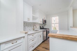 9201 Shore Road, Unit C209 Brooklyn, NY 11209 - Photo 9 of 23 a kitchen with granite countertop white cabinets and white appliances