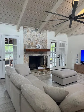 a living room with furniture large window and a fireplace