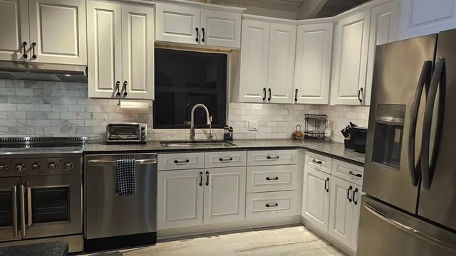 a kitchen with stainless steel appliances granite countertop a refrigerator sink and cabinets