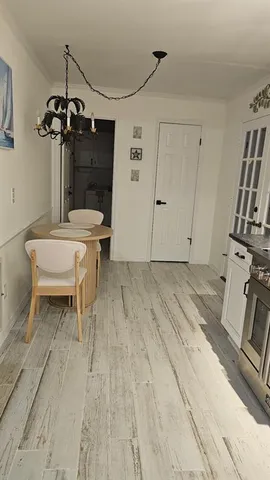 a view of a room with a wooden floor and chandelier