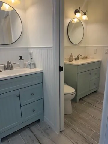 a bathroom with a toilet a sink and mirror
