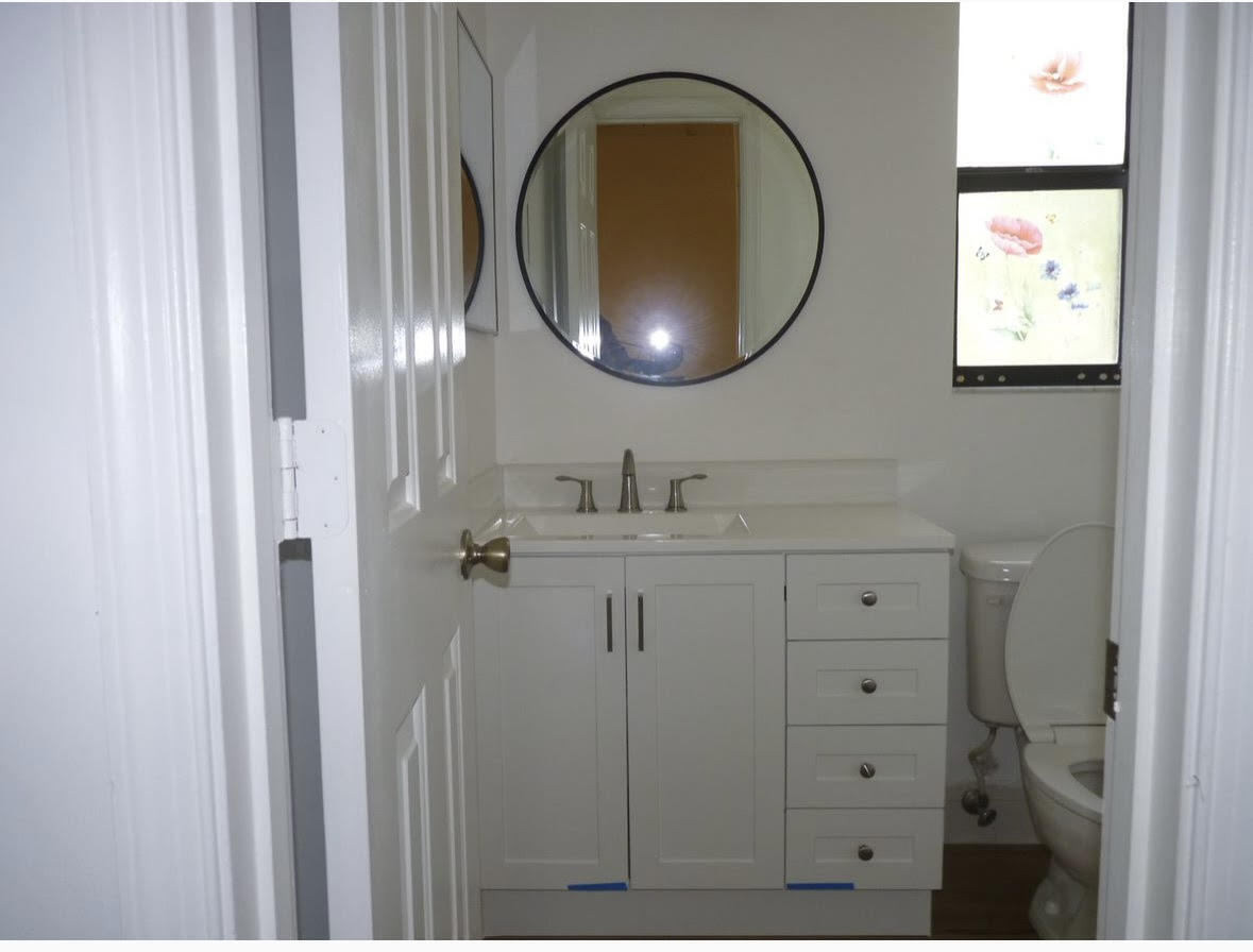 3130 Millwood Terrace, Unit 2120 Boca Raton, FL 33431 - Photo 10 of 15 a bathroom with a sink and a mirror