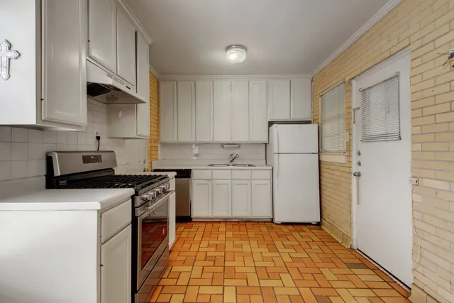 a kitchen with a sink a refrigerator and cabinets