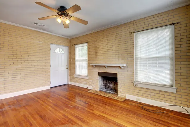 a view of an empty room with a fireplace and a window