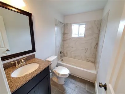 a bathroom with a granite countertop sink toilet a mirror and bathtub