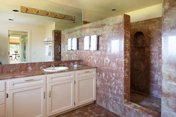 a bathroom with a granite countertop sink mirror and a bathtub