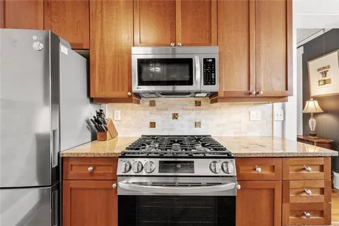 a kitchen with granite countertop a stove and a microwave
