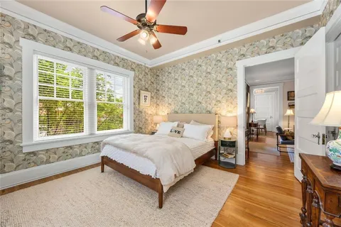a spacious bedroom with a bed a chandelier and a large window