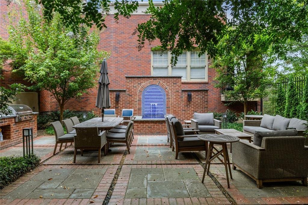 266 11th Street Northeast, Unit 203 Atlanta, GA 30309 - Photo 35 of 50 a view of a patio with couches and a fire pit and large trees