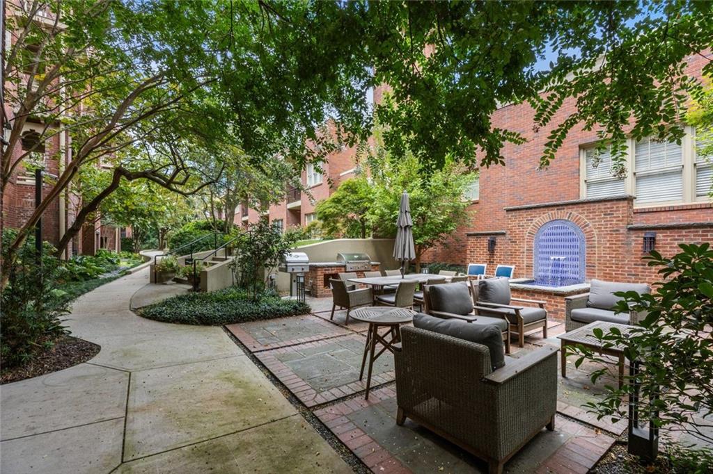 266 11th Street Northeast, Unit 203 Atlanta, GA 30309 - Photo 36 of 50 a view of a patio with table and chairs potted plants and large tree