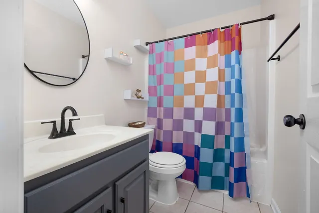 a bathroom with a sink a toilet a shower and a mirror