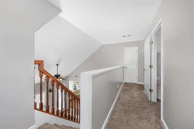 a view of a hallway with wooden floor and entryway
