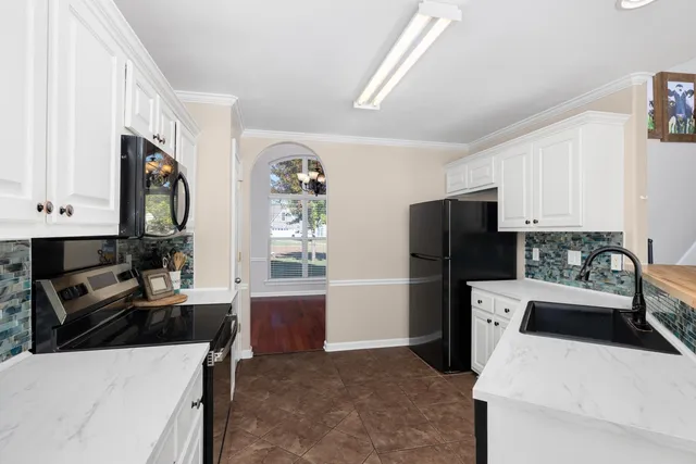 a kitchen with a refrigerator a stove a microwave a sink and cabinets