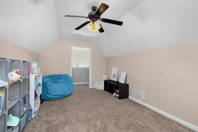 a living room with furniture and a ceiling fan