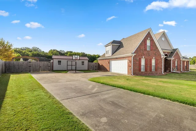 a house view with a big yard plants and large trees