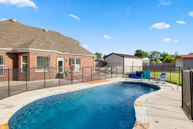 a view of a house with backyard and sitting area