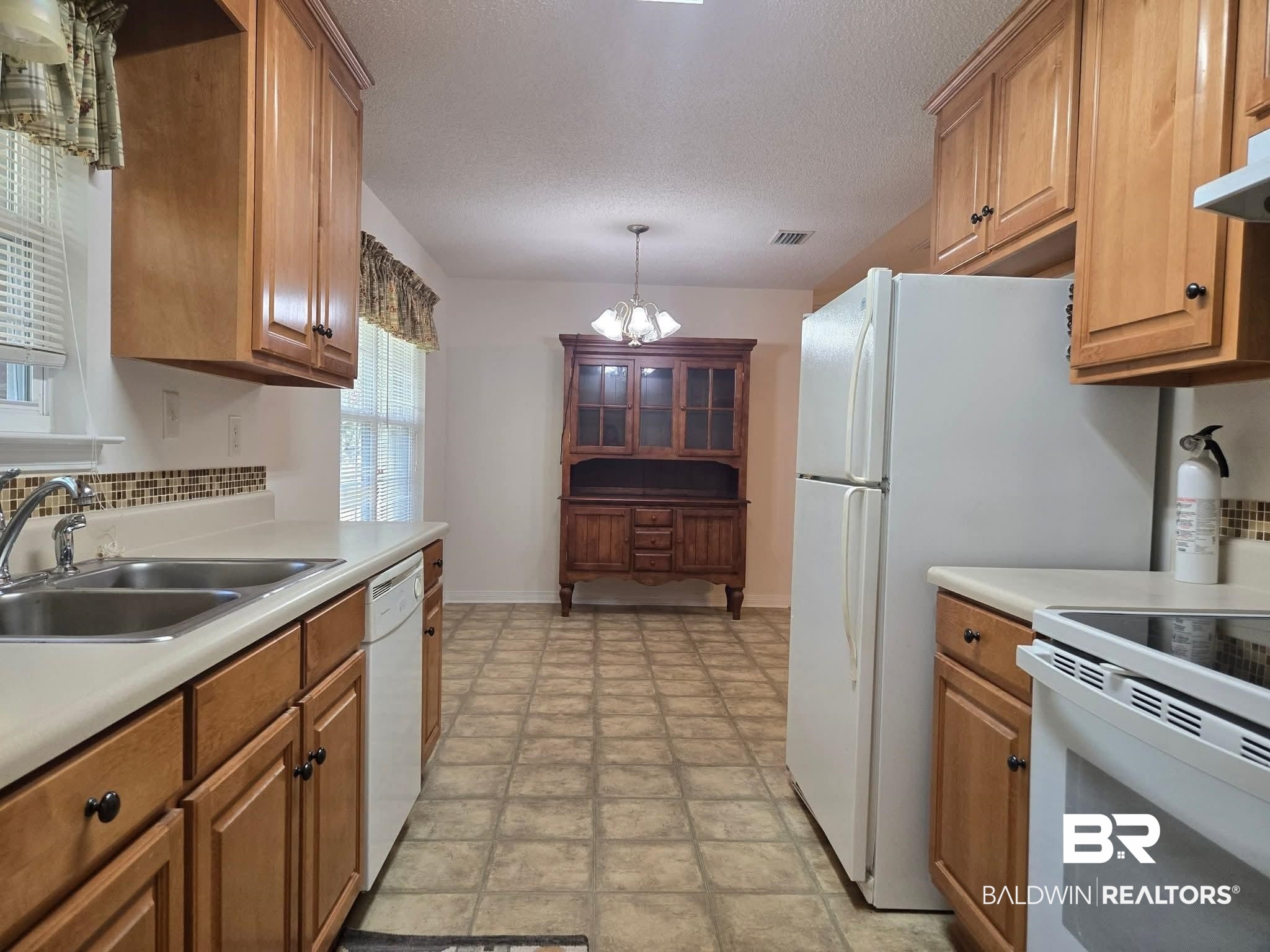 2554 Riverside Drive Mobile, AL 36605 - Photo 6 of 43 Kitchen featuring light countertops, white appliances, pendant lighting, a textured ceiling, and a chandelier