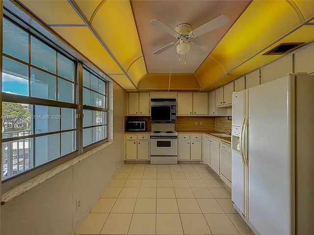 a kitchen with white cabinets stainless steel appliances and sink