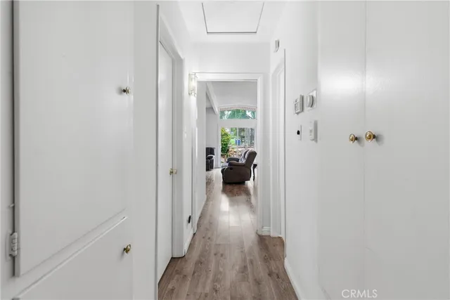 a view of a hallway with wooden floor and a living room