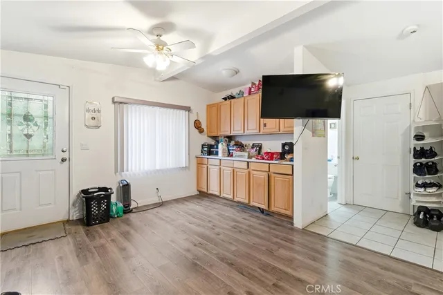 a living room with a flat screen tv and kitchen view
