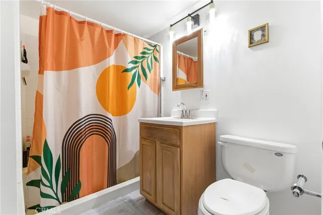 a bathroom with a sink a mirror a toilet and a window