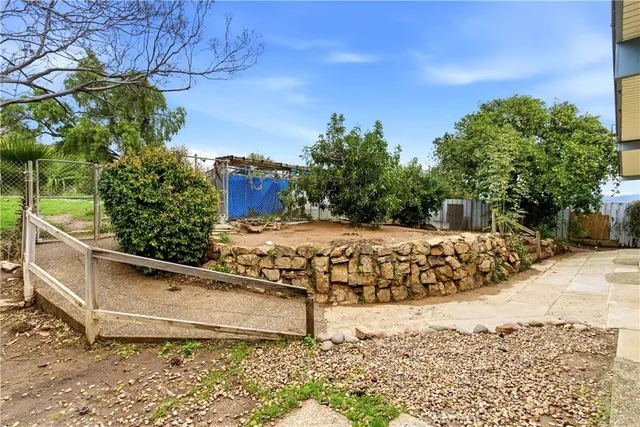 a view of a yard with wooden fence