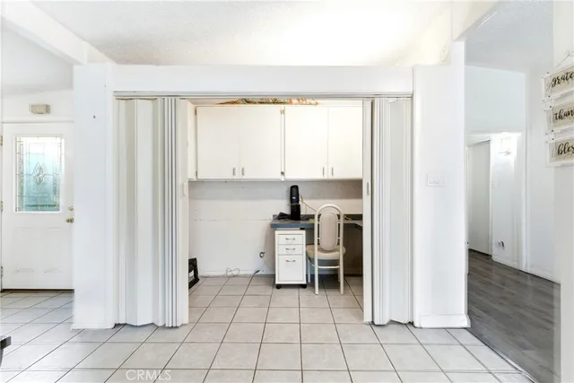 a view of a kitchen with chair and refrigerator