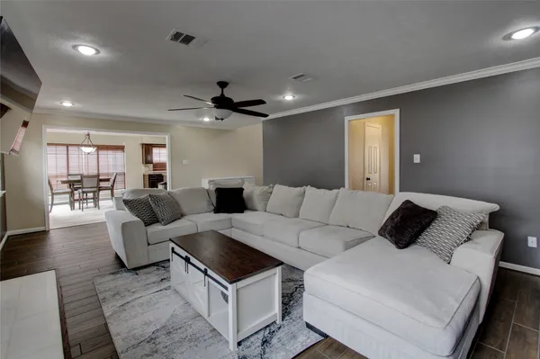 a living room with furniture and a wooden floor