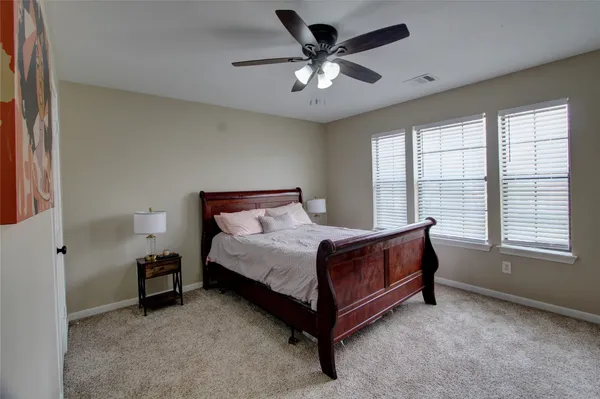a spacious bedroom with a bed and a large window