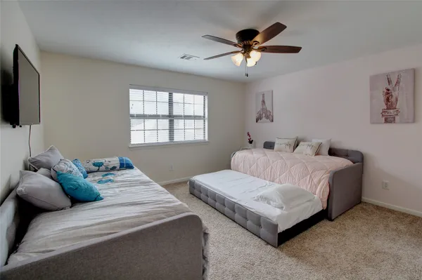 a bedroom with a bed and a ceiling fan