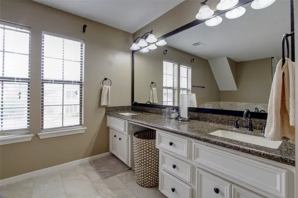 a bathroom with a double vanity sink and a mirror