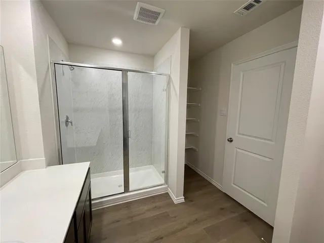 a bathroom with a double vanity sink mirror and shower
