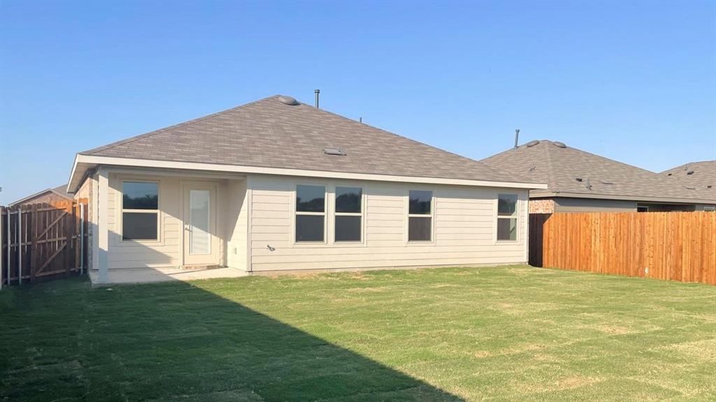 1452 Millstead Rill Road Caddo Mills, TX 75135 - Photo 22 of 24 Rear view of house with roof with shingles, a fenced backyard, and a patio