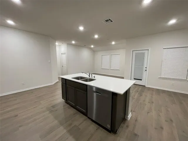 a large kitchen with stainless steel appliances kitchen island a large counter top and a stove top oven