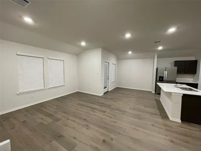 a view of a kitchen with a sink and wooden floor