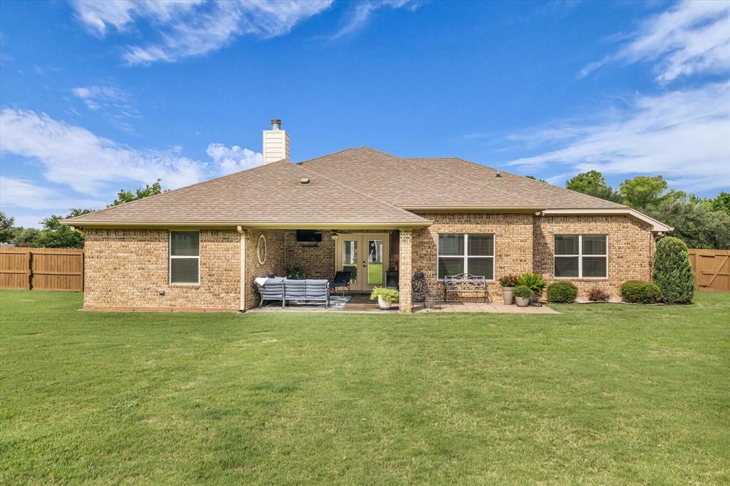 910 Springdale Lane Lorena, TX 76655 - Photo 30 of 39 Expansive rear elevation featuring a brick exterior, a covered patio, and a shingled roof