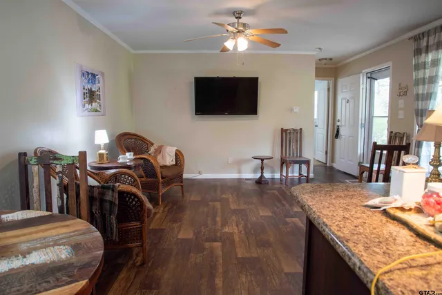 a view of a livingroom with furniture a flat screen tv and wooden floor