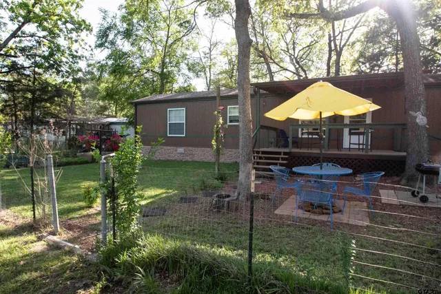 a backyard of a house with table and chairs