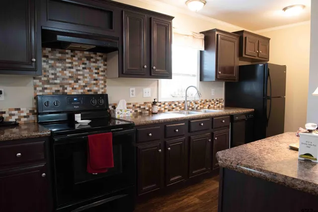 a kitchen with a sink a refrigerator and cabinets