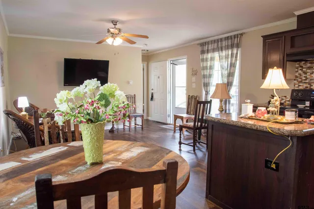 a dining room with furniture potted plants and wooden floor