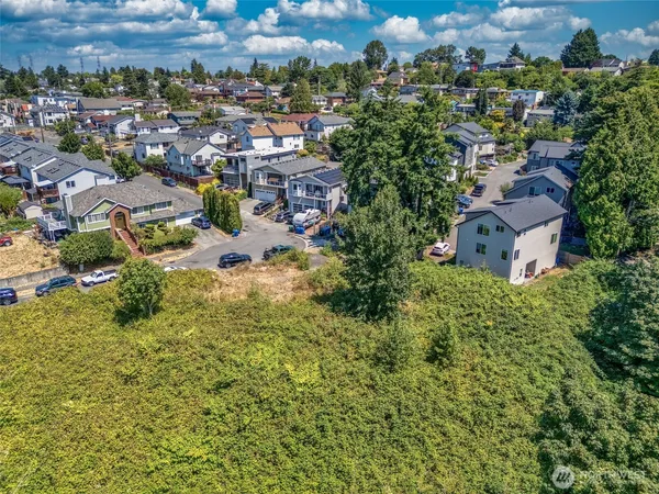 an aerial view of residential houses with outdoor space and trees
