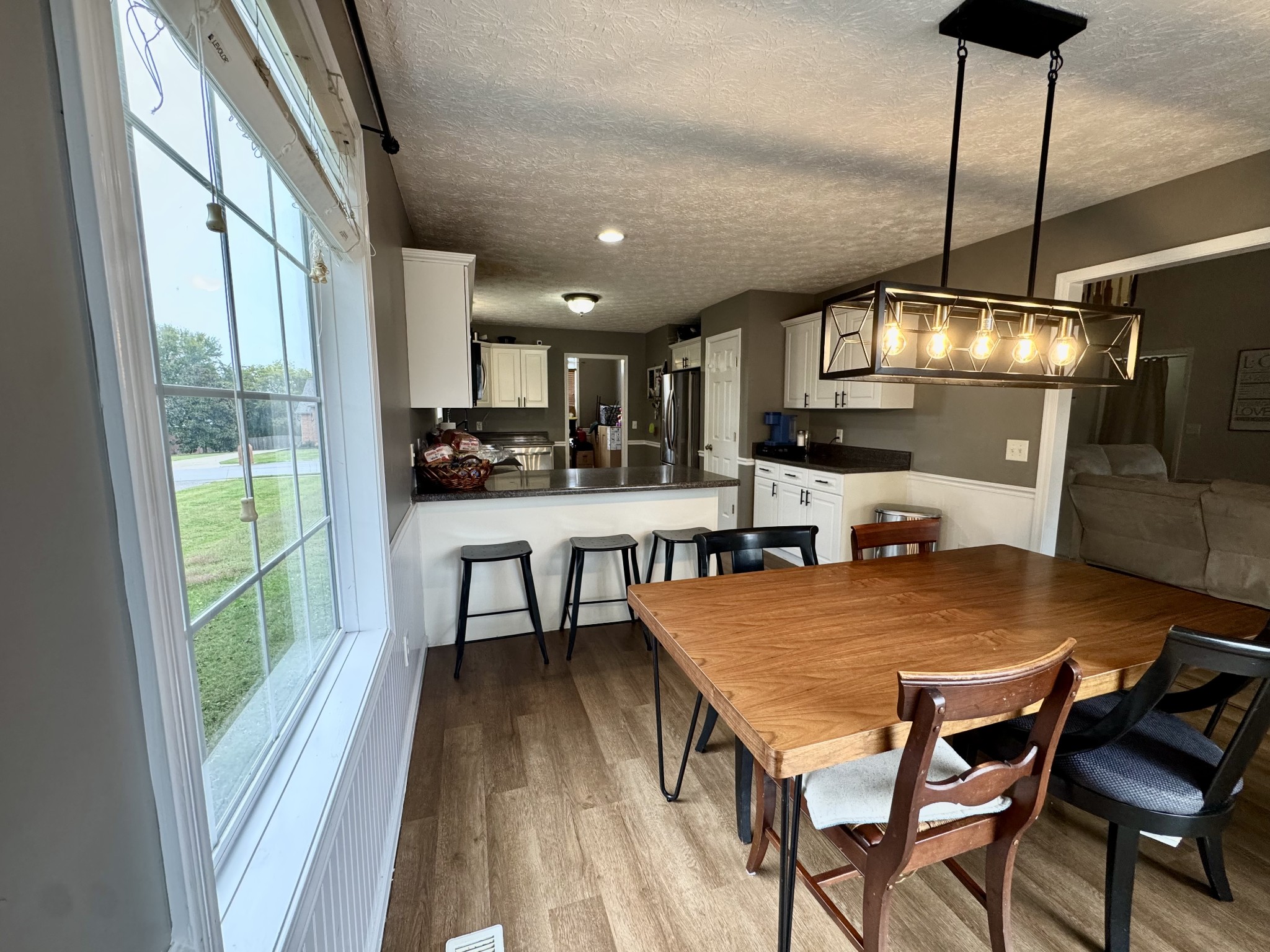 520 Briarhill Road Lebanon, TN 37087 - Photo 11 of 37 a kitchen with stainless steel appliances granite countertop a stove top oven a sink a dining table and chairs with wooden floor