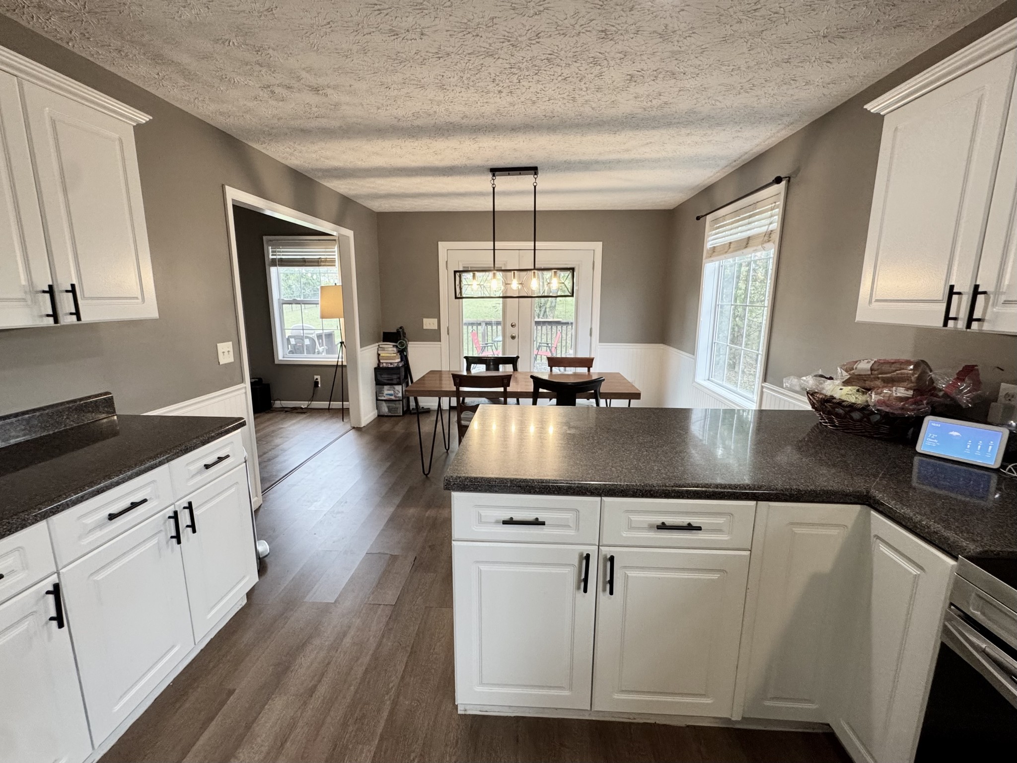 520 Briarhill Road Lebanon, TN 37087 - Photo 7 of 37 a kitchen with granite countertop a stove a sink and white cabinets with wooden floor