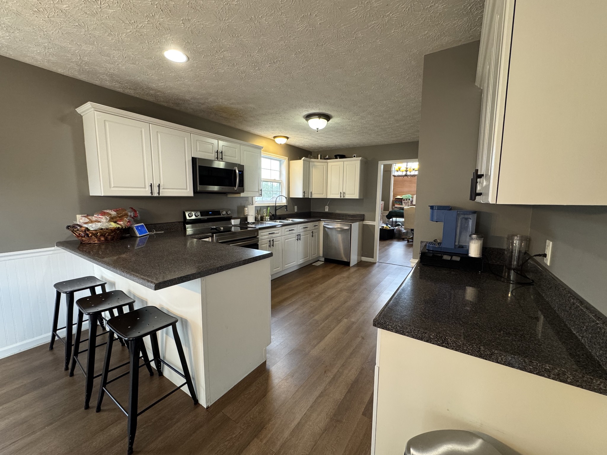 520 Briarhill Road Lebanon, TN 37087 - Photo 9 of 37 a kitchen with granite countertop a stove a sink a microwave a dining table and chairs