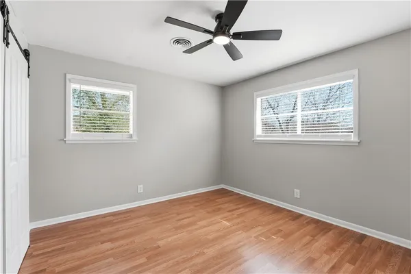 an empty room with a window and a fan