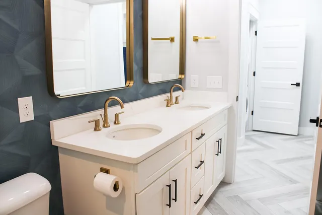 a spacious bathroom with a double vanity sink a mirror and a bathtub